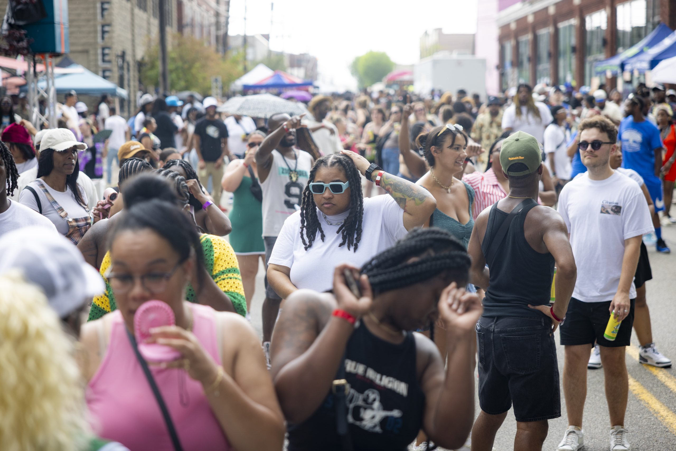 Packed daytime street party in Pittsburgh with vendor tents and a large crowd