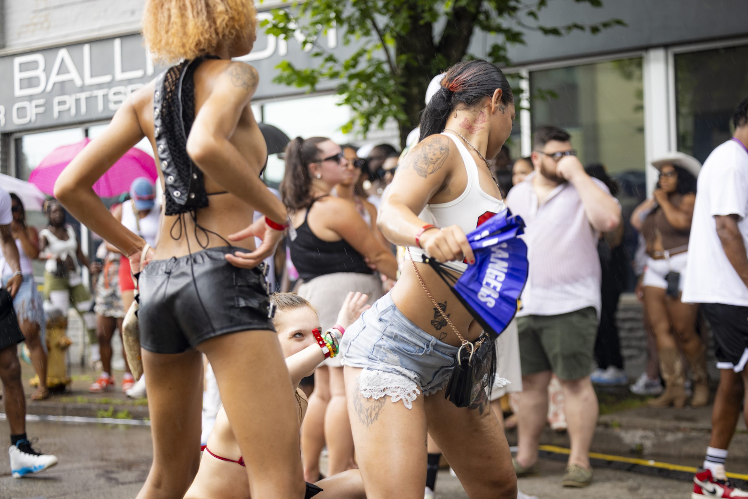 Women dancing in the street in summer outfits at a Slappers N Bangers outdoor block party in Pittsburgh