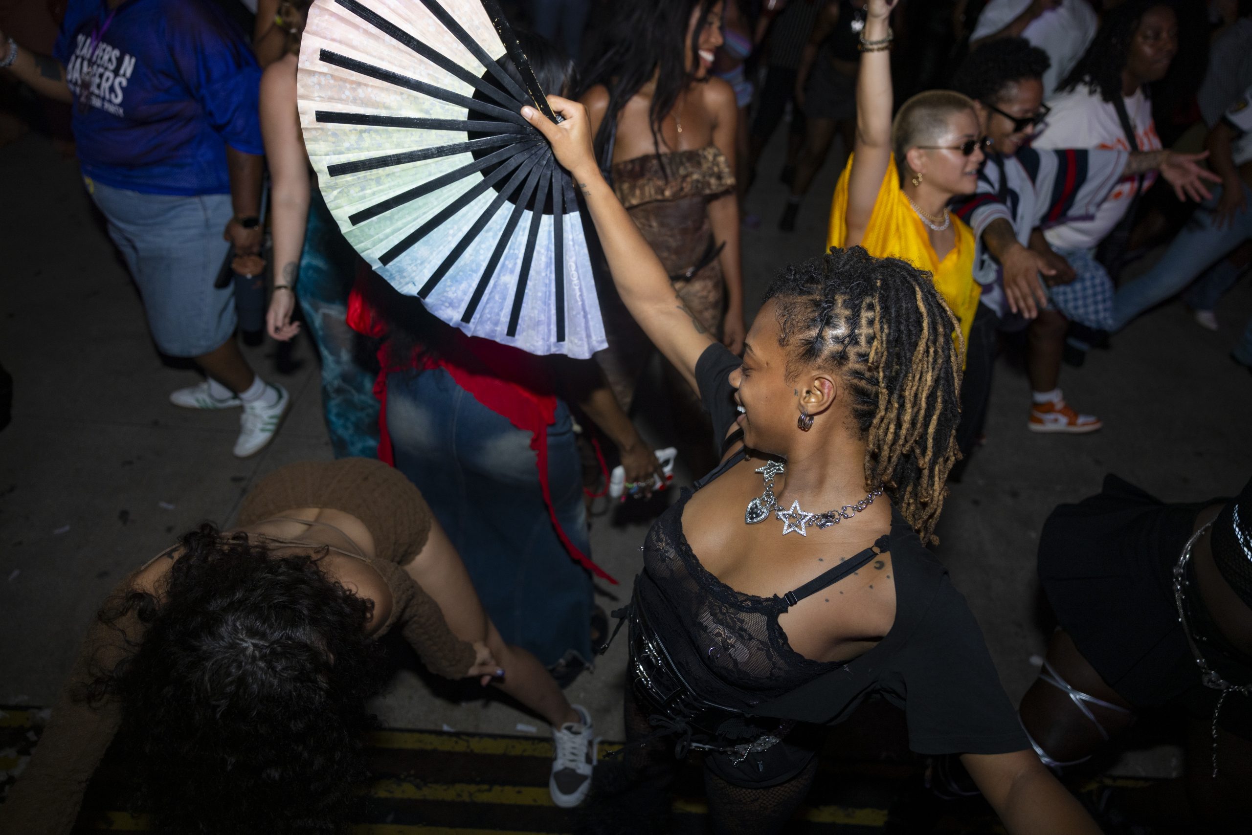 Crowd dancing with a hand fan raised at a Slappers N Bangers hip hop and R&B party in Pittsburgh