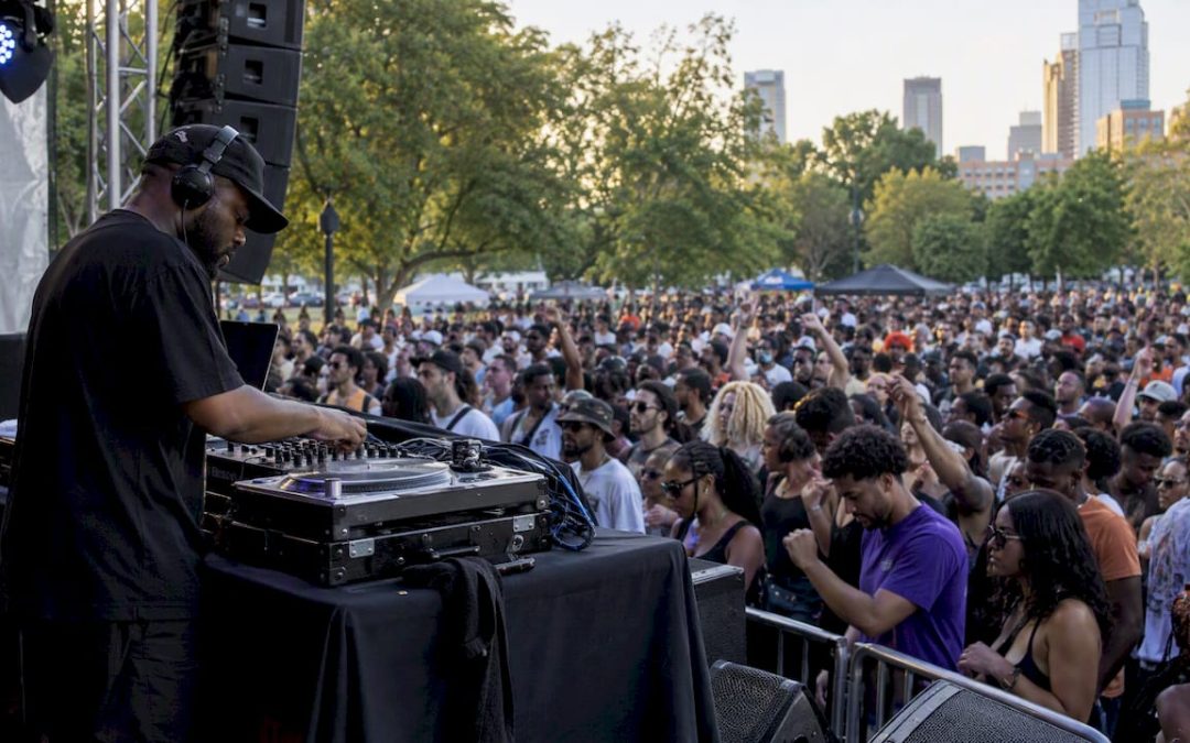 DJ performing for an outdoor hip hop festival crowd