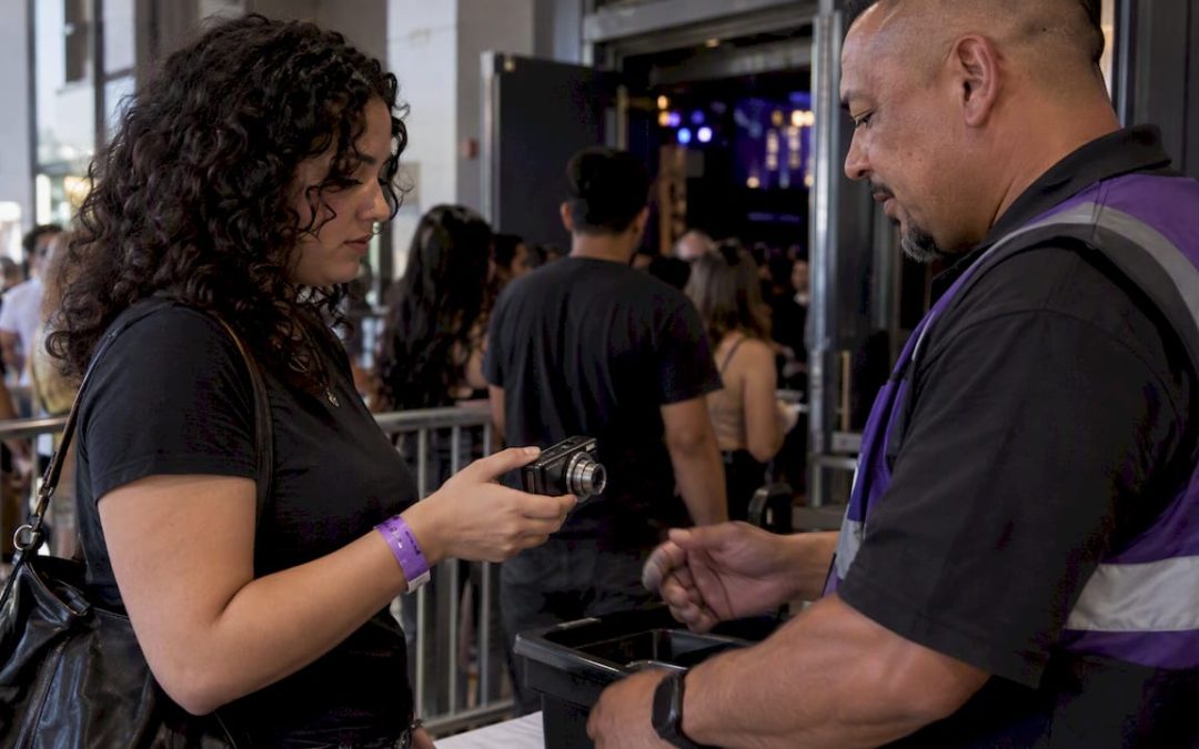 Staffer checks compact camera at concert entrance