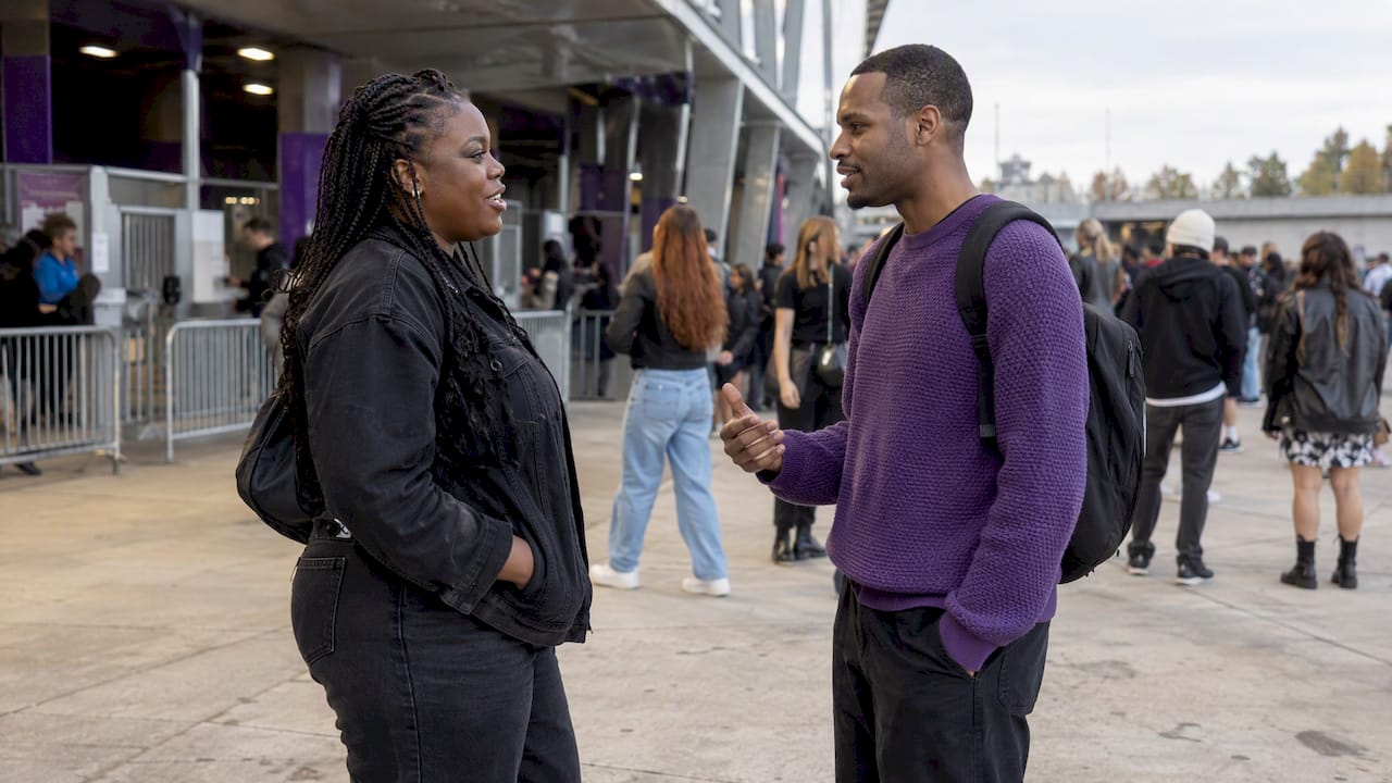 Two attendees meeting at a public venue landmark