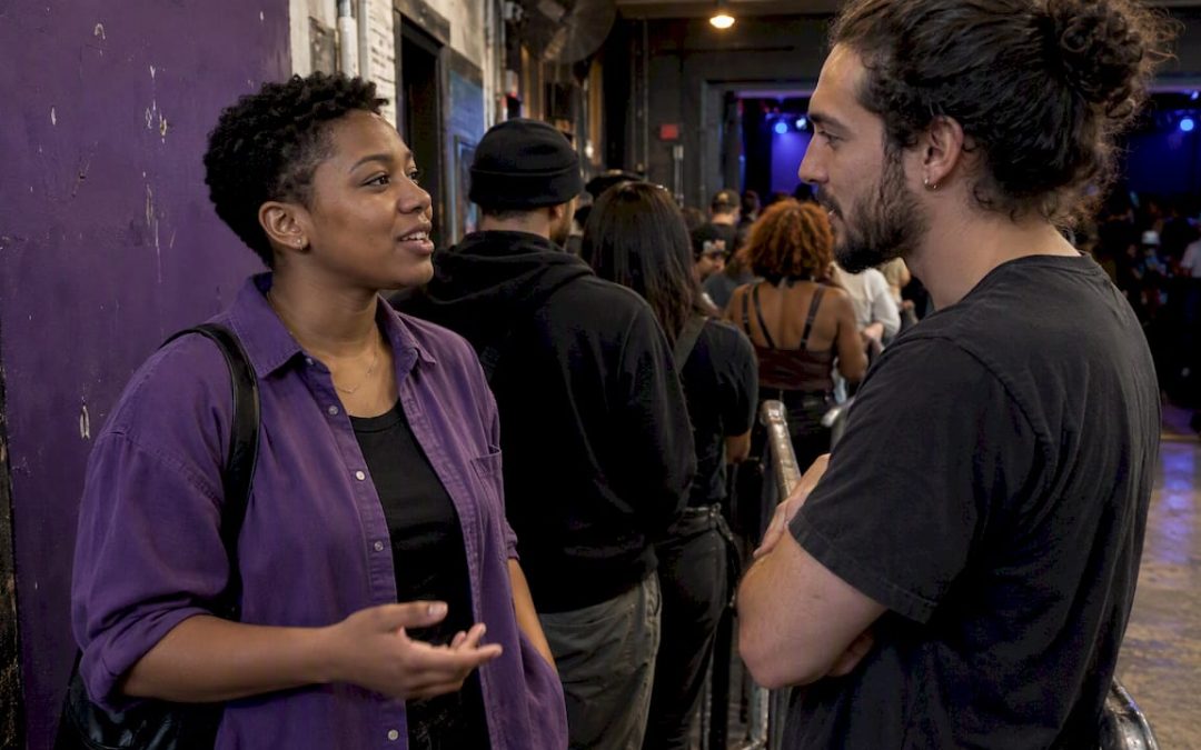 Two concertgoers chatting in a venue queue