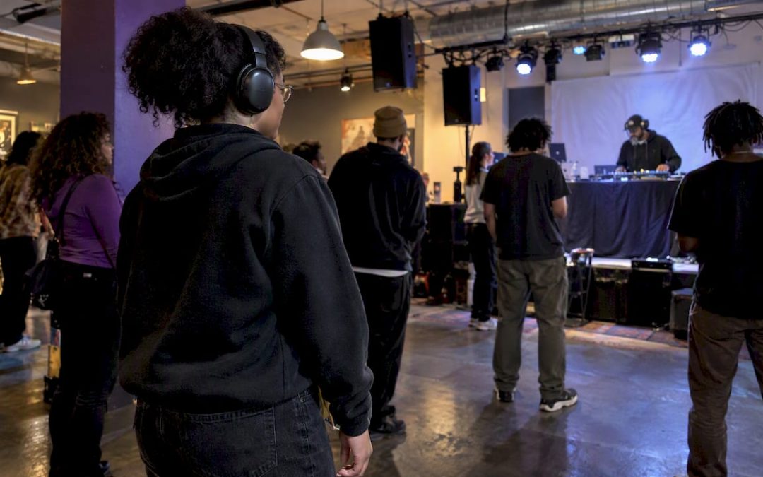 Listener wearing headphones at a relaxed hip-hop concert